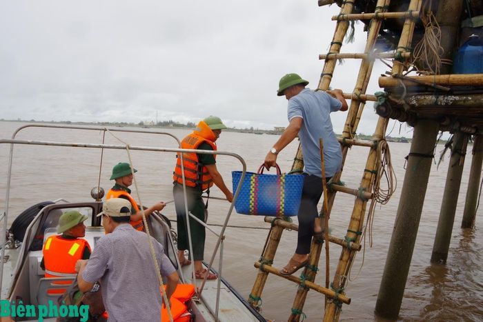 Cán bộ Đồn Biên phòng Quất Lâm, Bộ đội Biên phòng tỉnh Ninh Bình vận động, đưa ngư dân ở các lều, chòi vào bờ tránh bão. Ảnh: Minh Khôi