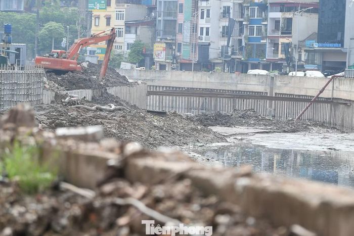 Dưới lòng kênh, máy xúc hoạt động liên tục để nạo vét bùn, vận chuyển đất lên xe tải. Tiếng máy móc và xe ben gần như không ngừng suốt cả ngày.