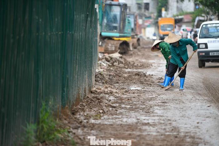 Công nhân vệ sinh mặt đường, thu dọn bùn đất sau mưa nhằm hạn chế ảnh hưởng đến việc đi lại của người dân trong quá trình thi công.