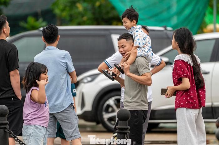 Nhiều khách du lịch ở nơi khác đến tranh thủ trời ngớt mưa ra biển chụp ảnh check-in trước giờ bão về.