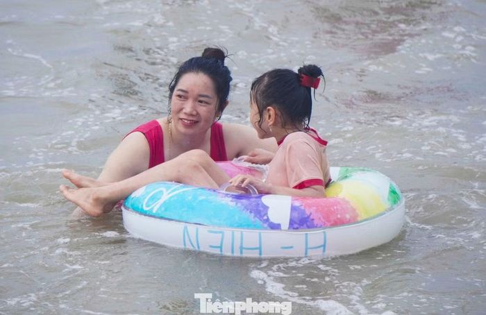 Trẻ em được người thân theo sát khi tắm biển.