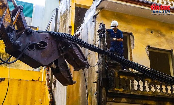 Công nhân xử lý hệ thống dây cáp điện trước khi phá dỡ công trình.