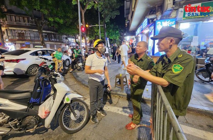 Một thanh niên hỏi lực lượng chức năng phương án di chuyển về nhà thuận lợi khi xe xăng bị cấm đi lại trong vùng lõi của phường Hoàn Kiếm.