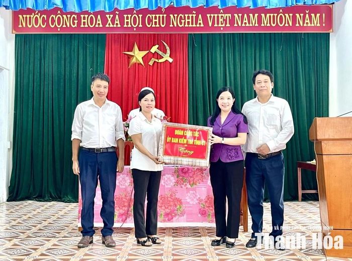 Chủ nhiệm Ủy ban Kiểm tra Tỉnh ủy Phạm Thị Thanh Thủy tặng quà cho Chi bộ thôn Hưng Long.