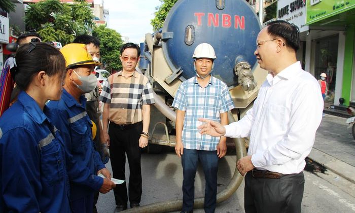  Đồng chí Phạm Văn Thịnh trò chuyện, động viên công nhân thi công dự án tại đường Lê Lợi. 