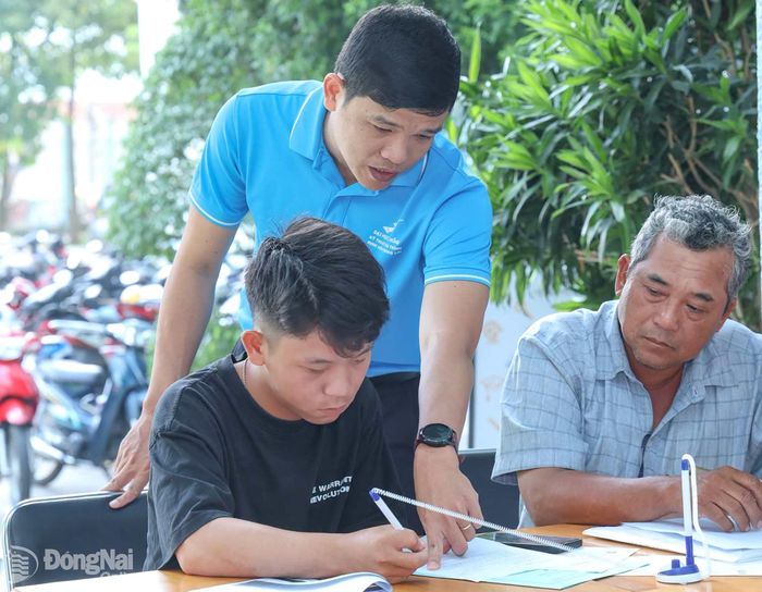 Chuyên viên tuyển sinh Trường đại học Lạc Hồng hướng dẫn thí sinh và người nhà đăng ký xét tuyển trực tiếp. Ảnh: CN