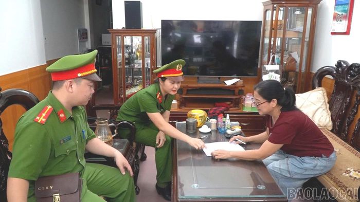 Công an phường Yên Bái hướng dẫn bà Trịnh Thị Loan kê khai thông tin đăng ký cung cấp mẫu ADN.