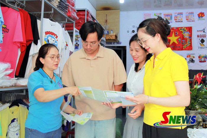 Cán bộ BHXH tỉnh và các các tổ chức hỗ trợ phát triển đối tượng tư vấn chính sách BHYT cho hộ kinh doanh địa bàn phường Tô Hiệu.