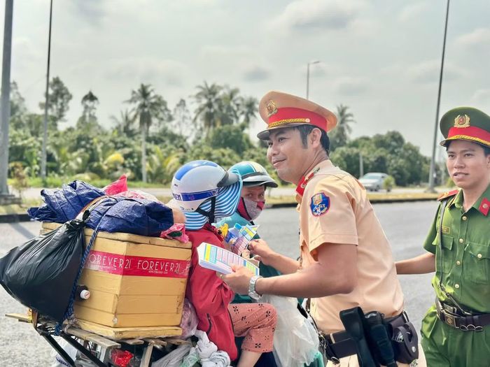 Cán bộ CSGT phát nước suối miễn phí, lồng ghép tuyên truyền về trật tự an toàn giao thông.