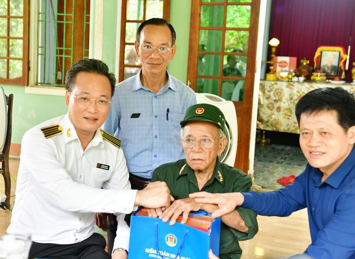 Tổng Kiểm toán nhà nước Nguyễn Hữu Nghĩa tặng quà thương binh Phạm Sắt. Ảnh: N. Lộc