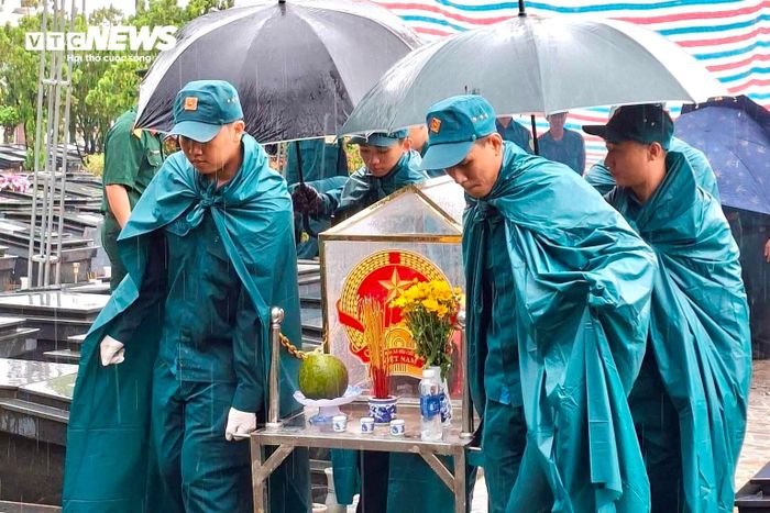 Một phần hài cốt được di chuyển về khu lấy mẫu. Cơn mưa bất chợt không làm gián đoạn công việc của các tổ công tác.