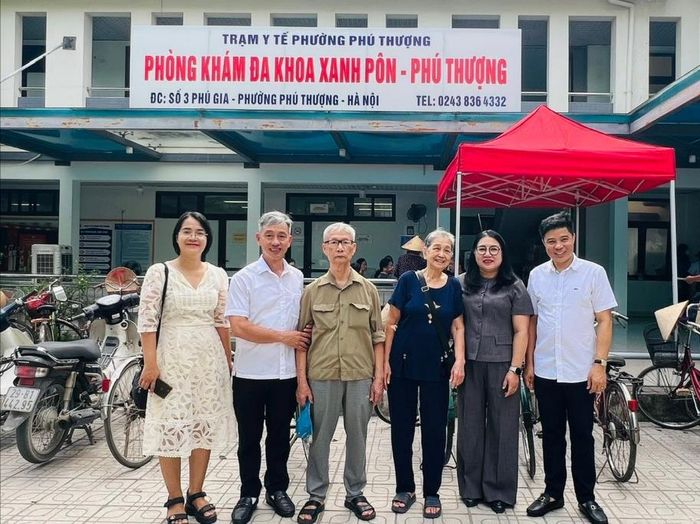 Vợ chồng cụ Phùng Chí Thức và cụ Nguyễn Thị Vui, tổ dân phố Phú Gia 3, chụp ảnh lưu niệm cùng lãnh đạo phường và các y, bác sĩ sau buổi khám sức khỏe. Ảnh: Lê Hà