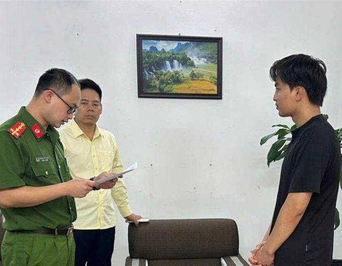 Nguyễn Quang Lợi (bên phải ảnh) nghe Quyết định khởi tố để điều tra về hành vi sản xuất, buôn bán hàng giả. Ảnh: Công an tỉnh Cao Bằng. 