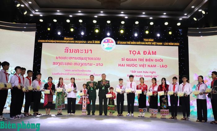 Đại tá Đao-kay Lợt-li-văn và Đại tá Nguyễn Quốc Hiếu trao học bổng cho các em học sinh. Ảnh: Viết Lam