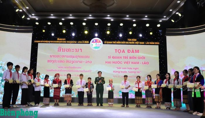 Thiếu tướng Vũ Quốc Ân trao học bổng cho các em học sinh. Ảnh: Viết Lam