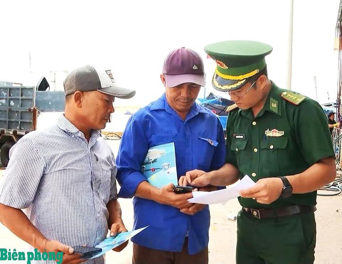 Cán bộ Trạm Kiểm soát Biên phòng Đà Nông hướng dẫn ngư dân cài đặt và sử dụng phần mềm eCDT. Ảnh: Thùy Dung