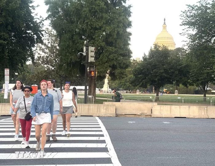 Người dân di chuyển quanh khu vực National Mall, Washington D.C trong bối cảnh đợt nắng nóng cực đoan đã buộc ban tổ chức điều chỉnh lịch nhiều hoạt động kỷ niệm 250 năm Quốc khánh Mỹ và hủy cuộc diễn hành dự kiến diễn ra ngày 4/7. (Ảnh: Đoàn Hùng/TTXVN)