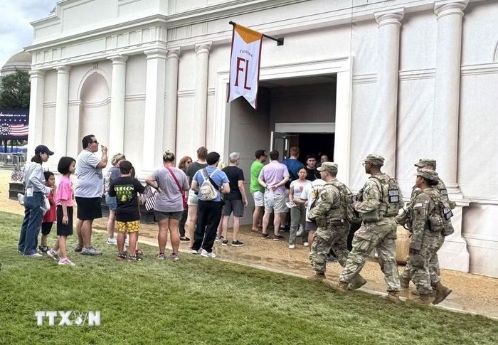 Người dân xếp hàng vào khu vực triển lãm trong khuôn khổ Lễ hội Great American State Fair tại Washington D.C., trong khi lực lượng Vệ binh Quốc gia và Ban tổ chức căng mình bảo đảm an ninh, an toàn trước điều kiện thời tiết khắc nghiệt. (Ảnh: Đoàn Hùng/TTXVN)