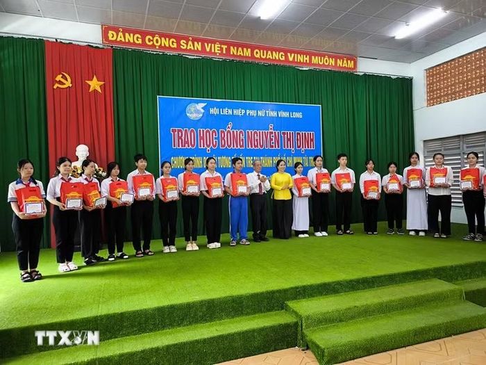 Trao học bổng Nguyễn Thị Định cho học sinh vượt khó học giỏi. (Ảnh: Huỳnh Phúc Hậu/TTXVN)
