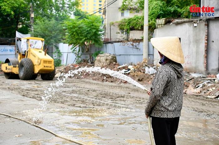 Công nhân tưới nước giảm bụi tại khu vực thi công.