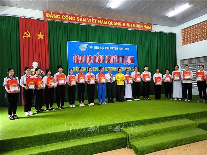 Trao học bổng Nguyễn Thị Định cho học sinh vượt khó học giỏi. Ảnh: Huỳnh Phúc Hậu/TTXVN