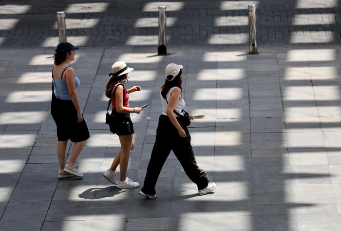 Người dân di chuyển trên đường phố dưới trời nắng nóng tại Seville, Tây Ban Nha. Ảnh: THX/TTXVN