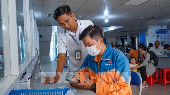 Thành viên Tổ Công nghệ số cộng đồng hướng dẫn người dân cài đặt và sử dụng các ứng dụng số, góp phần lan tỏa Phong trào “Bình dân học vụ số” đến từng hộ gia đình. Ảnh: Minh Phú – TTXVN