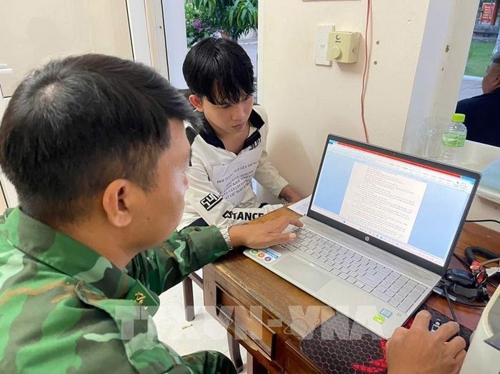 Lực lượng chức năng lấy lời khai hai Đối tượng Nguyễn Trung Hậu. Ảnh: TTXVN phát