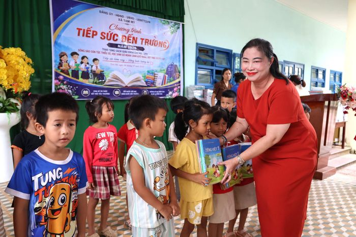 PGS, TS Vũ Thị Phương Anh, Hiệu trưởng Trường Cao đẳng Quảng Nam trao tặng sách cho các em học sinh đồng bào Co xã Tam Mỹ. Ảnh: XUÂN THƯƠNG