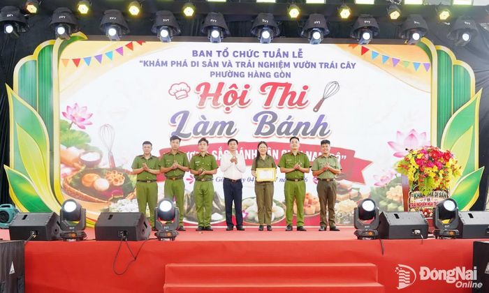 Phó Bí thư Đảng ủy, Chủ tịch UBND phường Hàng Gòn Hoàng Trọng Phương trao giải nhất Hội thi làm bánh cho đội Công an phường. Ảnh: Lê Tiên