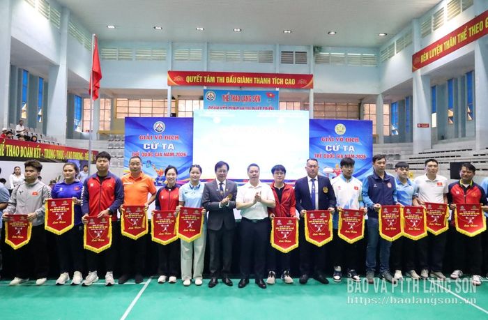 Đồng chí Đoàn Thanh Sơn, Phó Chủ tịch UBND tỉnh và Tổng Thư ký Liên đoàn Cử tạ, Thể hình Việt Nam trao cờ lưu niệm cho đại diện các đoàn vận động viên