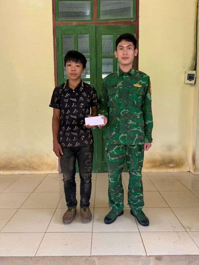 Đồng chí Đàm Trường Giang, nhân viên trinh sát, Đồn Biên phòng Tổng Cọt trao trả điện thoại cho cháu Thào Mý Đứ.