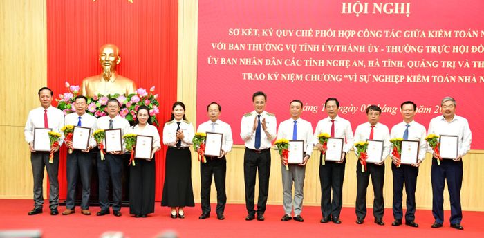 Tổng Kiểm toán nhà nước Nguyễn Hữu Nghĩa, Phó Tổng Kiểm toán nhà nước Hà Thị Mỹ Dung trao tặng Kỷ niệm chương vì sự nghiệp KTNN cho lãnh đạo các tỉnh, thành phố và lãnh đạo sở, ngành các địa phương. Ảnh: N. LỘC