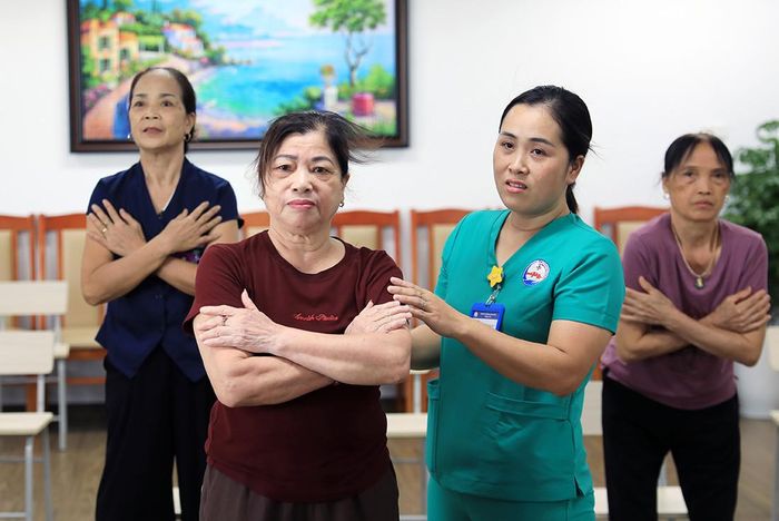 Chị Nguyễn Thị Hải (cán bộ điều dưỡng) tận tình hỗ trợ người cao tuổi trong mỗi buổi tập.