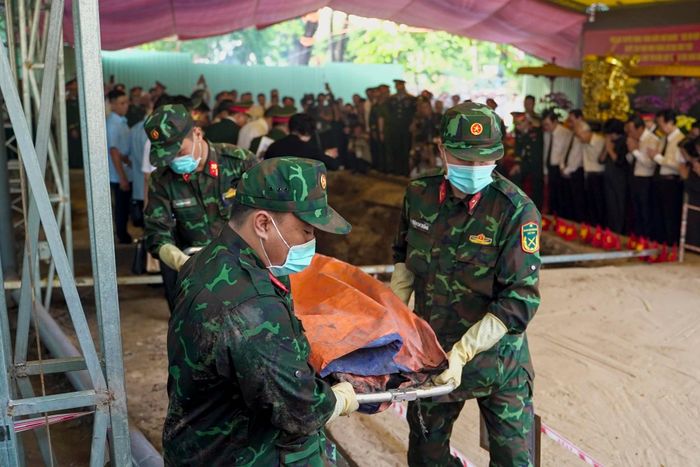 Lực lượng tìm kiếm tại hiện trường đưa hài cốt tìm thấy sáng 6/7 đến khu vực quy tập, chuẩn bị an vị trong linh cữu. Ảnh: Duy Hiệu.