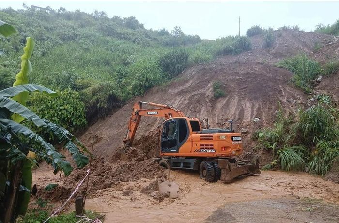 Đơn vị thi công huy động máy xúc khắc phục điểm sạt lở taluy dương tại Km 0+960 trên tuyến đường Huổi Só - Huổi Lóng. Ảnh: TTXVN phát