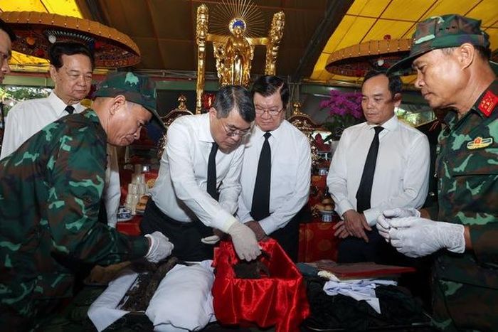 Thủ tướng Chính phủ Lê Minh Hưng cùng các đại biểu thực hiện nghi thức quy tập hài cốt liệt sĩ - Ảnh: VGP/Nhật Bắc