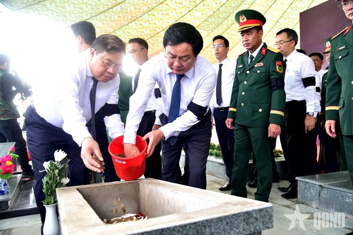 Những nắm đất đầu tiên được các đại biểu thành kính vun lên phần mộ các liệt sĩ.