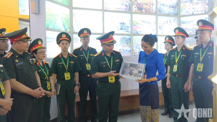 Đại úy Lê Hảo, Phó trưởng ban Thanh niên Quân đội, Trưởng đoàn Sĩ quan trẻ Quân đội nhân dân Việt Nam tặng quà lưu niệm cho Bảo tàng Kaysone Phomvihane. 
