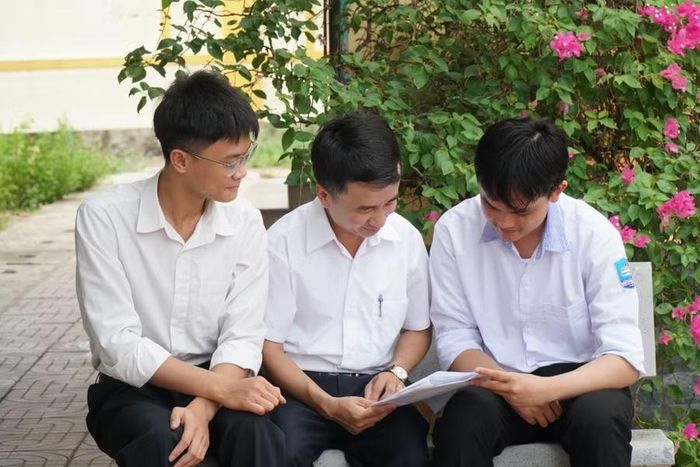 Đình Phong cùng thầy giáo chủ nhiệm và bạn học cùng lớp. Ảnh: Hồ Lài