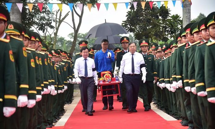 Phó thủ tướng Thường trực Chính phủ Phạm Gia Túc cùng các đại biểu đưa hài cốt liệt sĩ đến nơi an táng. Ảnh: Tiến Bin