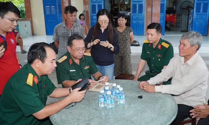 Thiếu tướng Nguyễn Thành Trung - Chính ủy Bộ Tư lệnh TPHCM (hàng ngồi, thứ hai từ trái qua) đang xác minh thông tin nhân thân liệt sĩ Huỳnh Văn Quên. Ảnh: Nguyên Phú