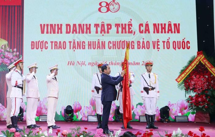 Thừa ủy quyền của Chủ tịch nước, Bí thư Thành ủy Hà Nội Trần Đức Thắng gắn Huân chương Bảo vệ Tổ quốc hạng Nhất lên lá cờ truyền thống của lực lượng Công an Thủ đô Anh hùng.