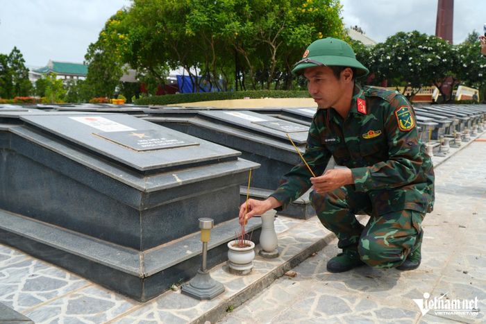 Trung tá Vũ Duy Quyền thắp nhang cho các phần mộ liệt sĩ chưa xác định thông tin tại Nghĩa trang liệt sĩ Trảng Bom. Ảnh: Hoàng Anh