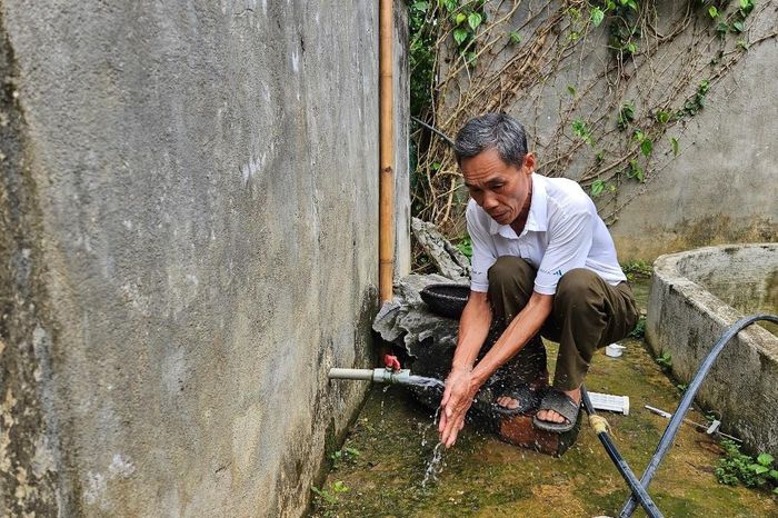 Ông Lữ Văn Quang sử dụng nước từ công trình cấp nước sinh hoạt tập trung tại thôn Tân Phong. Ảnh: Quỳnh Trâm