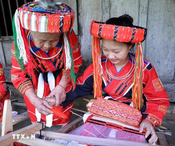 Tri thức làm trang phục truyền thống vẫn được trao truyền trong gia đình, dòng họ và cộng đồng Pà Thẻn. (Nguồn: TTXVN)