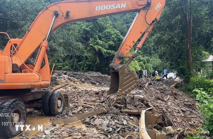 Các đơn vị tập trung phương tiện máy móc khắc phục hậu quả của mưa lũ gây ra tại km 81+100 trên Quốc lộ 12. (Ảnh: TTXVN phát)