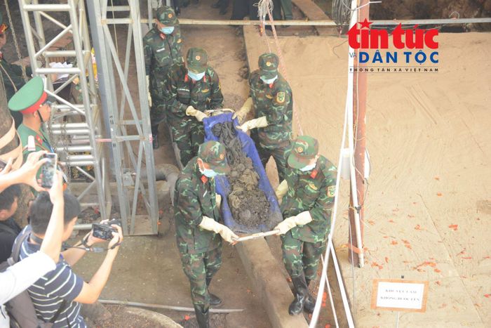 Lực lượng chức năng đưa hài cốt ra khỏi hố chôn tập thể tại Công viên Lê Thị Riêng.