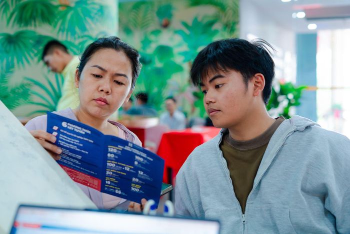Tân sinh viên cùng mẹ trao đổi về các thông tin của năm học mới.