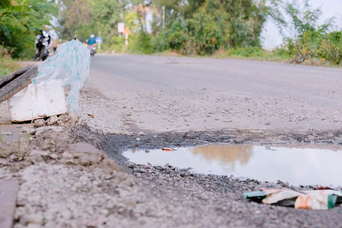 Mặt đường xuất hiện vũng nước nên người dân đã dùng thùng mướp, vỏ xe để cảnh báo người đi đường.